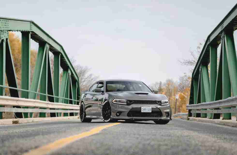 A yellow sports car is parked on a city street flanked by elegant buildings with large windows and arched entrances.